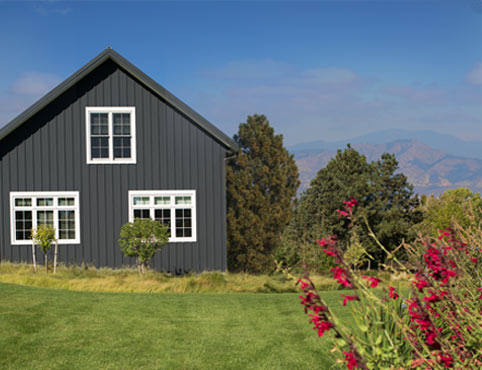 Vue de l’extérieur d’une maison de style ranch dans les Rocheuses avec parement en panneaux gris Satin Noir 2131-10. 