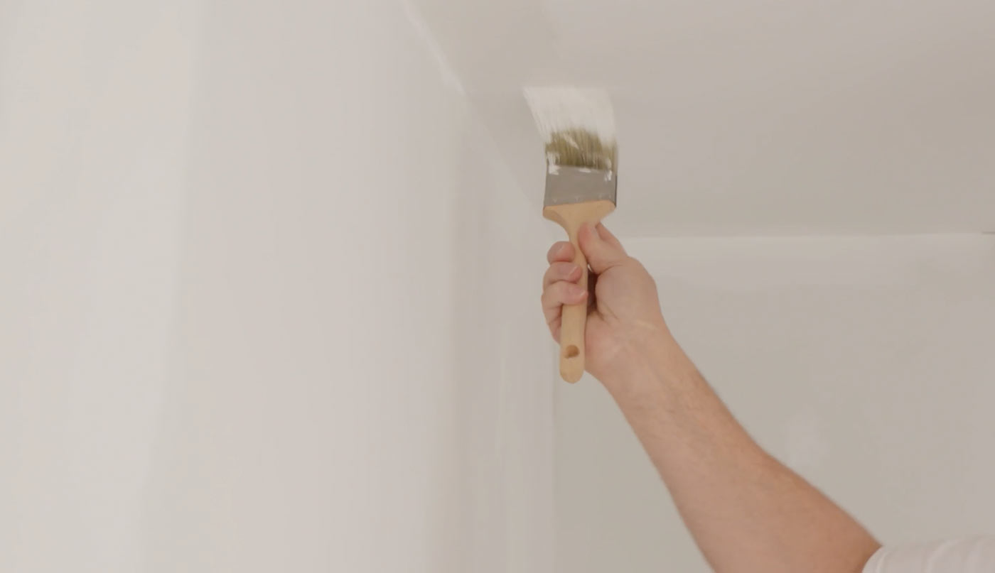 Man painting a white ceiling.