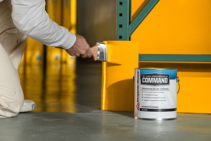 A person kneeling and brushing orange paint onto a section of wall behind a gallon of Benjamin Moore Command® Waterborne Acrylic Urethane. A person kneeling and brushing orange paint onto a section of wall behind a gallon of Benjamin Moore Command® Waterborne Acrylic Urethane.
