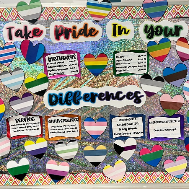 A Take Pride in Your Differences Board features Benjamin Moore employee birthdays, anniversaries, and colorful striped hearts.