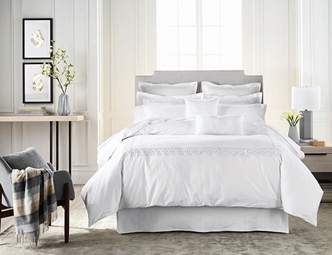 A serene bedroom features Benjamin Moore paint and Gluckstein Home bedding.