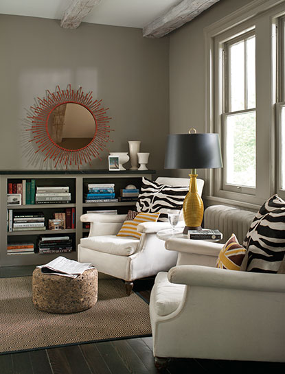 A cozy living room corner with two wing chairs and walls painted in Sparrow AF-720, a deep taupe colour.