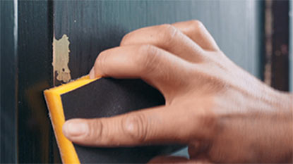 A person sanding a door.