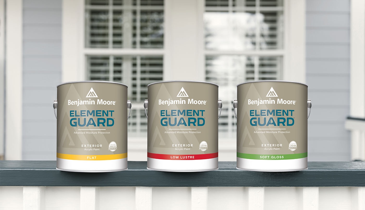 Three cans of Element Guard™ exterior paint sitting on a blue and white porch railing, in front of a window.