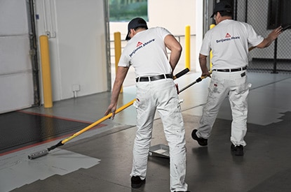 Painting contractors applying Corotech® COMMAND® on a warehouse floor.