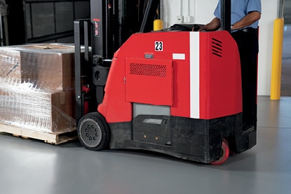A warehouse employee operating a motorized pallet jack on a floor coated in Corotech® COMMAND®.